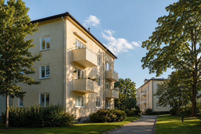 Illustration av ljusa flerbostadshus i en grön bostadsmiljö