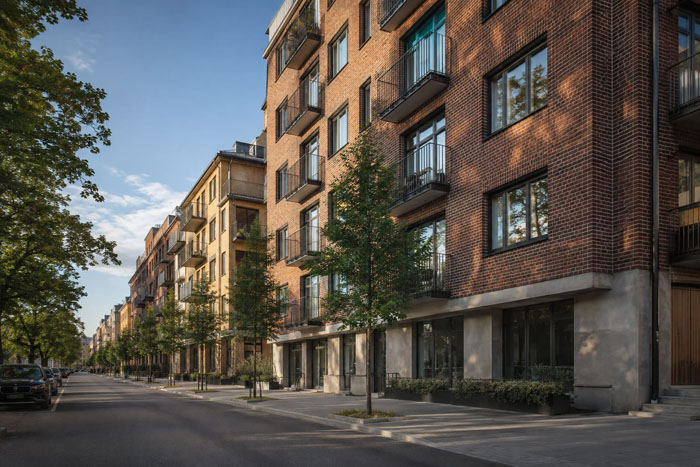 Illustration av en stadsgata med flerbostadshus i tegel